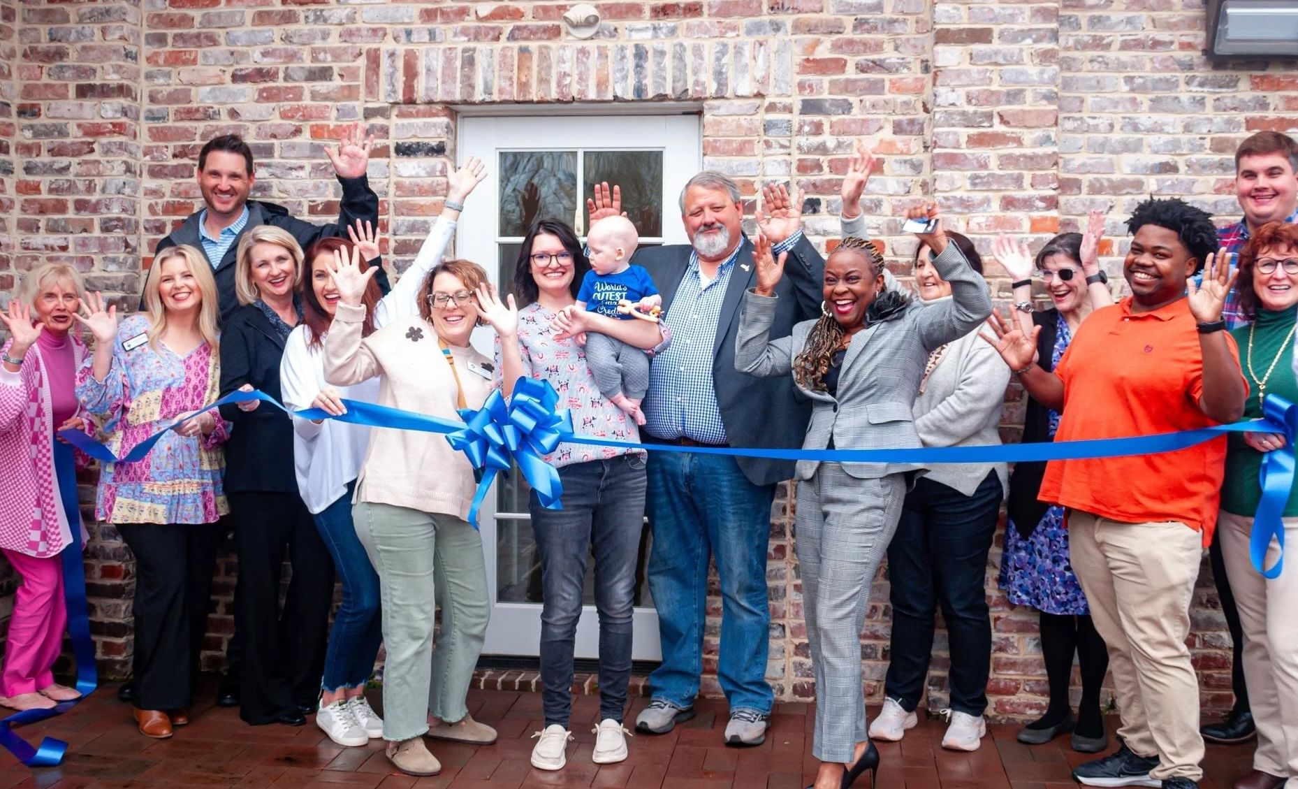 Photo of small business ribbon cutting with jazz hands in the air