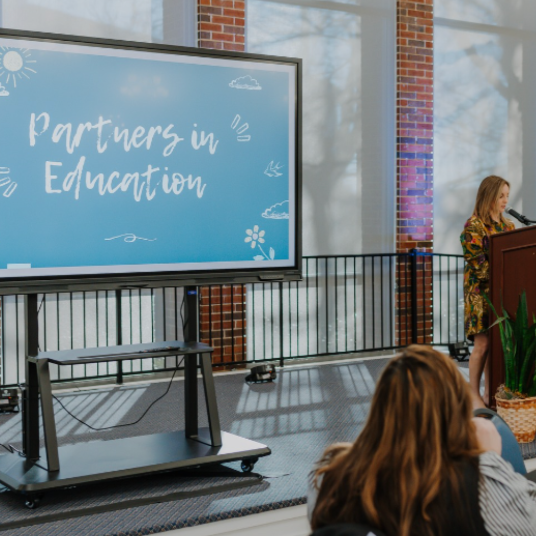 Photo from the 2024 Partners in Education breakfast, with Lauren Marsh at the microphone